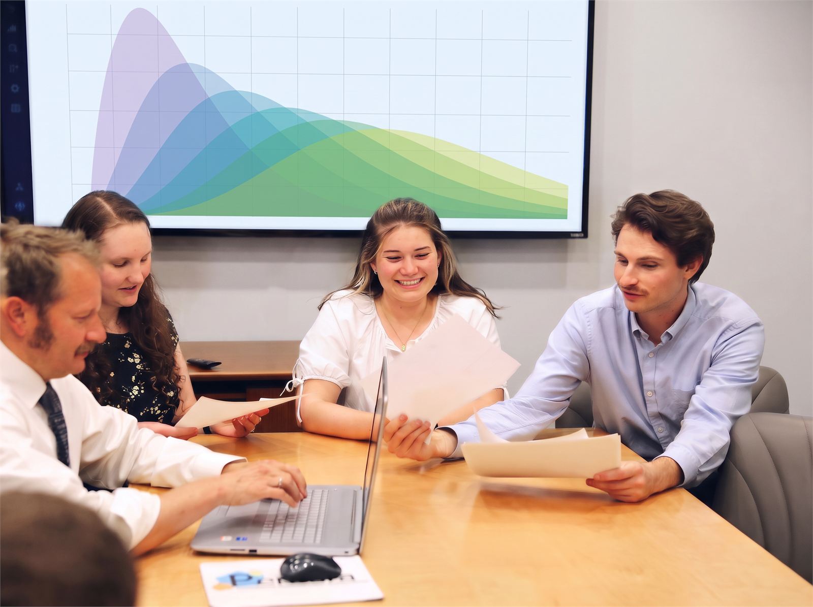 Pentara statisticians working through a trial analysis together at the conference table, trial data on the wall screen