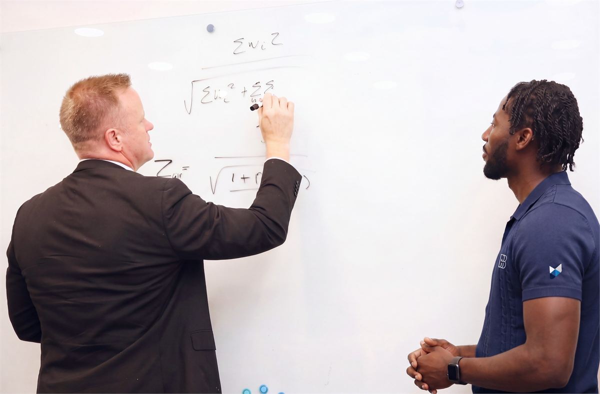 A Pentara statistician deriving the global statistical test on the whiteboard while a colleague follows the working